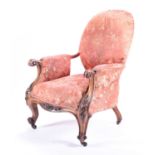 A Victorian upholstered armchair with carved mahogany part show frame, the well padded frame with