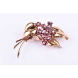 An Art Deco yellow gold, diamond, and ruby floral spray brooch, set with round-cut diamonds and