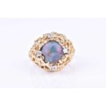 A 14k yellow gold, diamond, and opal ringin the Modernist taste, set with a round cabochon opal