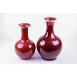 Two 20th century Chinese sang de boeuf vases, of similar form with flared rim and bulbous body,