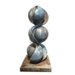 A large 20th century abstract bronze garden sculpture, with three shaped spheres on a square base,