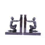 A pair of Art Deco style patinated spelter book rests, 20th century, the well patinated figures