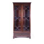 An early 20th century mahogany glazed bookcase, the interior fitted with four fixed shelves, above a