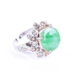 A diamond and jade cocktail ringthe raised mount with circular green jade plaque to center, the