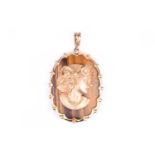 A 9ct yellow gold and tigers eye cameo style pendant, the oval tigers eye plaque with a scalloped