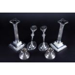 Three pairs of silver candlesticks, comprising a pair in the Geo III style with part reeded and