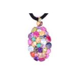 A yellow metal and multi-gem pendant of oval design, inset with mixed round and oval-cut rubies,