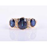 A mid to late 20th century yellow metal, diamond, and sapphire ringset with three mixed oval-cut