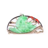 An Art Deco yellow metal and jade brooch, the stylised mount set with a jade ship, and a red