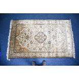 A 20th century Persian silk carpet, the central, shaped lozenge heavily decorated with foliate