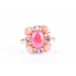 A 14ct yellow gold, ruby, and coral ringcentred with an oval cabochon ruby of approximately 3.40