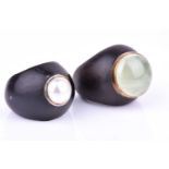 An ebony and green onyx ring, size M 1/2, together with a similar ebony and pearl ring, size M 1/2.