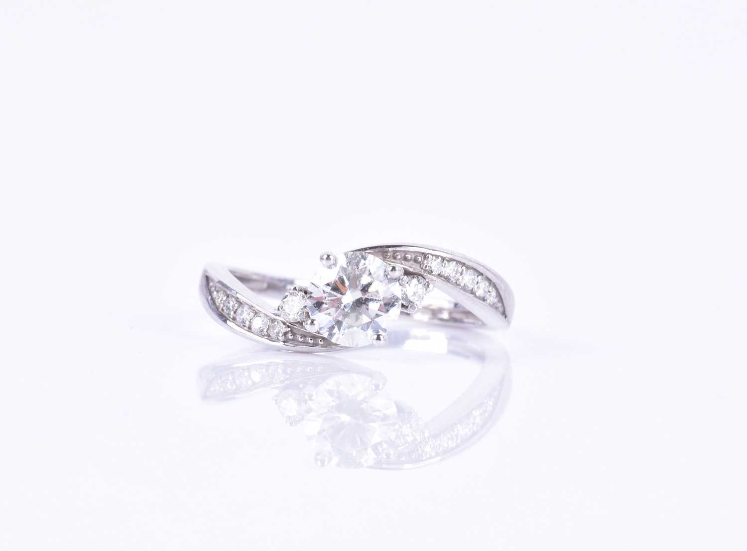 A 14ct white gold and diamond ring, centered with a round brilliant-cut diamond of approximately 0.