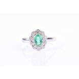 A 14ct white gold, diamond, and emerald ringset with an oval-cut emerald of approximately 0.45