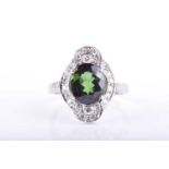 A platinum, diamond, and green tourmaline ringset with a mixed oval-cut tourmaline within a stylised