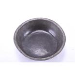 A large antique pewter bowl, probably 18th century, the rim bearing the initials 'AW' and 'IF', 25