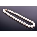 A cultured pearl necklacecomprised of rounded white pearls, approximate diameter 12 mm, fastened