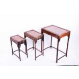 A set three Chinese hongmu carved nesting tables, with pierced foliate frieze on bamboo effect legs,