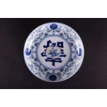 A Chinese wucai dished plate, late 20th century, the decoration of peaches and shou symbols