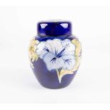 A Moorcroft Hibiscus pattern ginger jar and cover, the pale blue flowers against a dark blue ground,