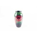 A Moorcroft Anemone pattern vase, the deep red flowers against a shaded green ground, green