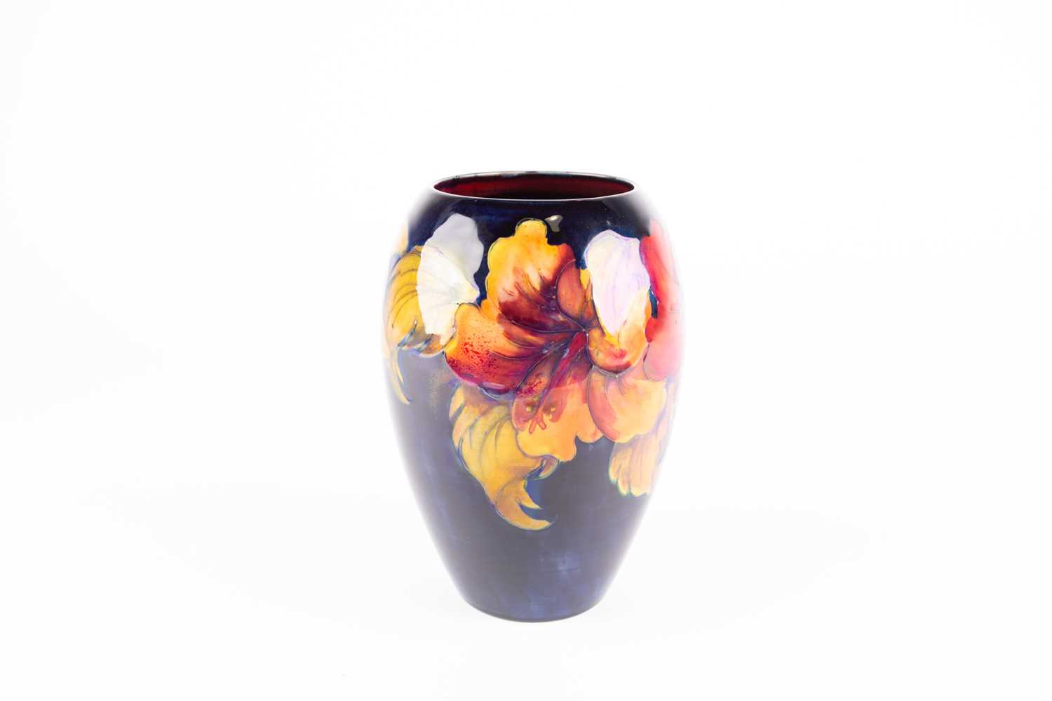 A Moorcroft Hibiscus pattern vase, of tapering form, the lustrous red and yellow flowers against a