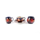 A William Moorcroft 'Pomegranate' pattern tea cup, saucer, cream jug and sugar bowl, circa 1920s/30s