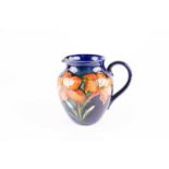 A Walter Moorcroft Freesia pattern jug, the blood orange flowers against a shaded blue ground,