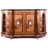 A 19th century figured walnut credenza with Sevres style plaques, the figured top with ebonised