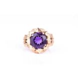 An 18ct yellow gold and amethyst dress ring, circa 1950s, set with a mixed round-cut amethyst,