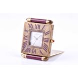 A Cartier travel clock, of square form with gilt metal case with claret lacquered Roman numerals,