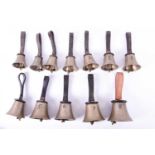 A collection of twelve early 20th century hand bells, each with leather stap handles, unnamed.