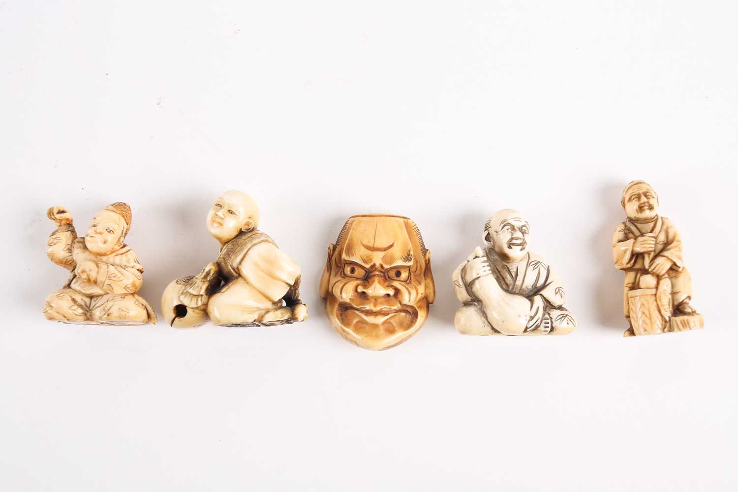 Five Japanese ivory netsukes, late 19th/early 20th century, to include a performer wearing a mask, a