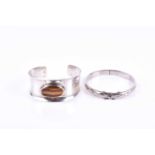 A Danish silver cuff bangle, inset with an oval tigers eye, internal diameter approximately 6 cm,