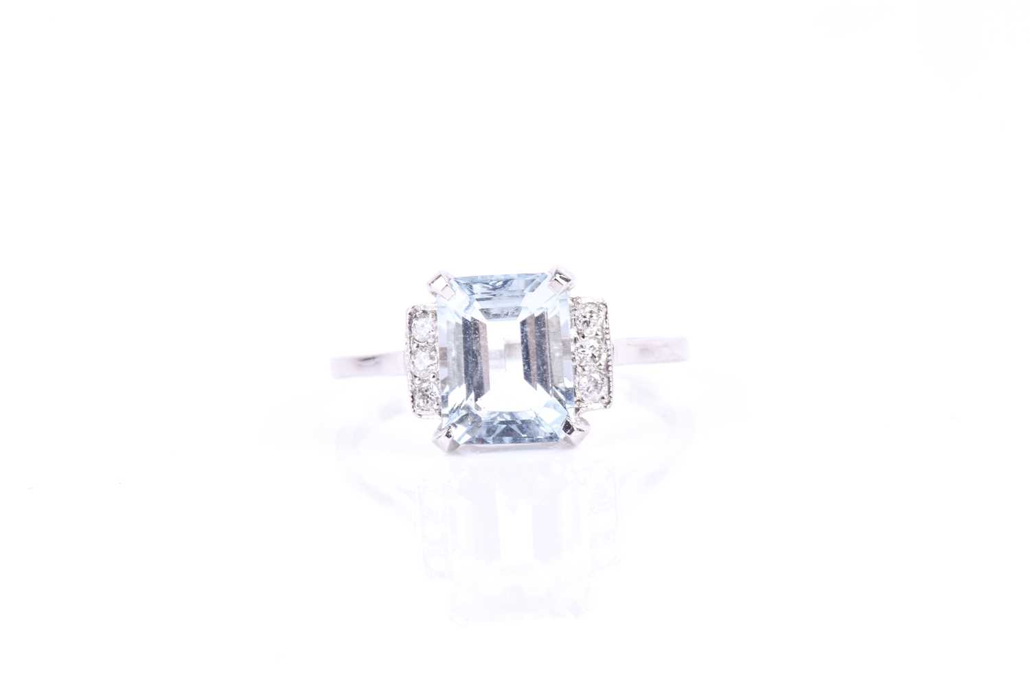 A platinum, diamond, and aquamarine ring, set with an emerald-cut aquamarine of approximately 2.0