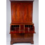 A George III mahogany secretaire bookcase, the top with dentil and blind-fret carved cornice, over a