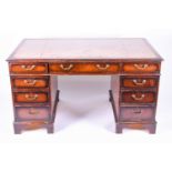 A reproduction mahognay nine-drawer pedestal desk, with tooled leather scriber, 135 cm x 76 cm x
