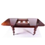 A Victorian mahogany extending dining table, with three leaves, the figured top with moulded