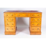 A Victorian satinwood veneered pedestal desk, the red leather inset top over three frieze drawers,