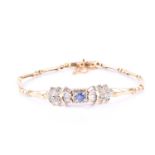 An 18ct yellow gold, sapphire, and clear cubic zirconia bracelet, centred with a oval sapphire,