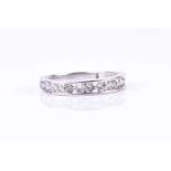 A white gold and diamond half eternity ring, channel-set with round brilliant-cut diamonds of