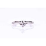 A platinum and diamond engagement ring, set with a round brilliant-cut diamond of approximately 0.45