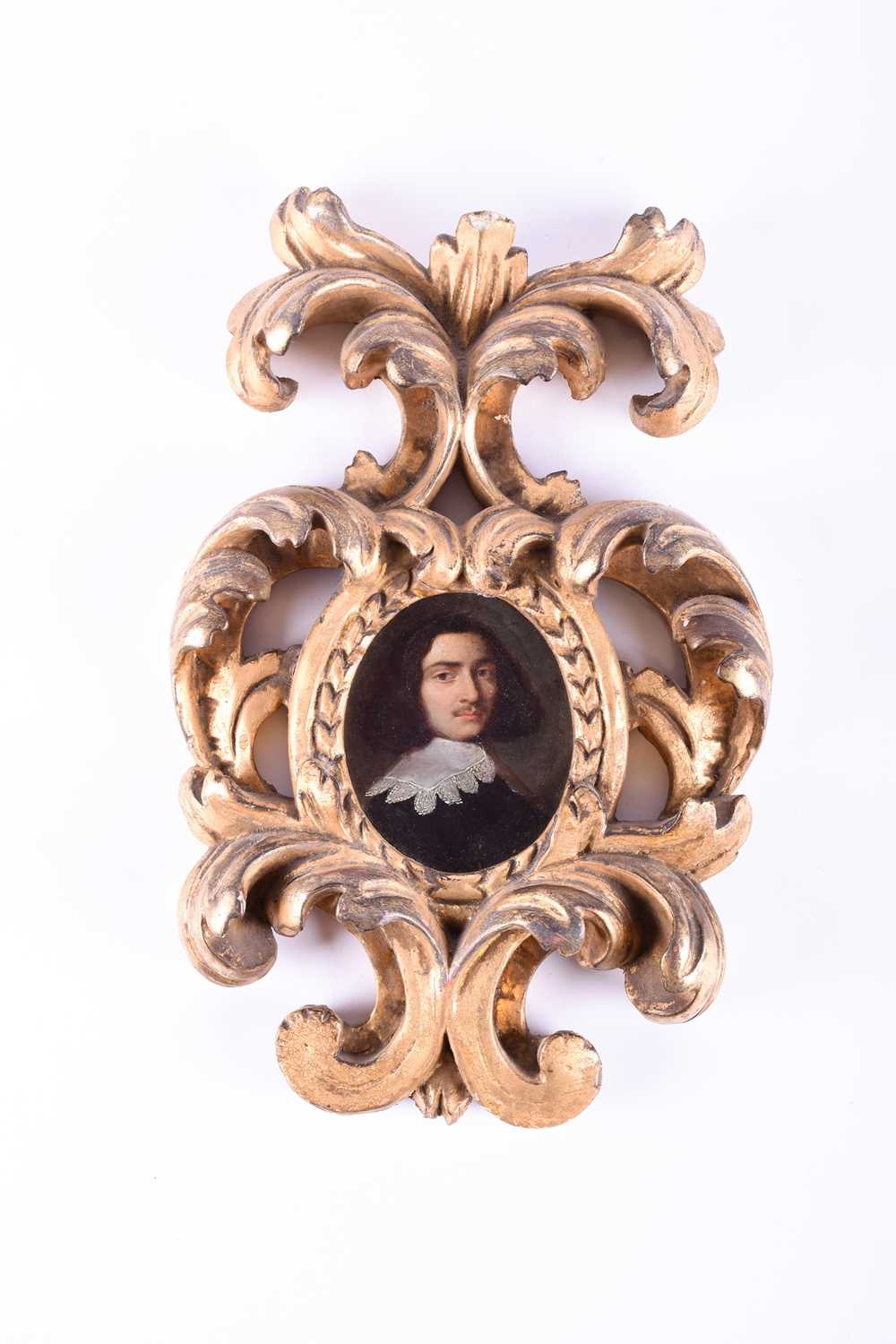 A 17th century oval portrait miniature of a gentleman, bust length wearing a white lace collar,