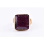 A yellow metal and corundum ring, set with a large rectangular-cut ruby (treated),1/5 x 1.4 cm,