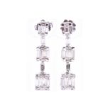 A pair of diamond triple cluster drop earrings, set with baguette and round-cut diamonds, the