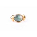 A yellow gold and cats eye tourmaline ringset east to west with an oval cabochon green tourmaline,
