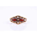 A 9ct yellow gold, garnet, and pearl ring, set with two mixed oval-cut garnets and four pearls,
