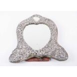 An Edwardian silver mounted dressing table mirror, Chester 1904, the heart shaped mirror framed by
