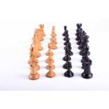 A Staunton turned and carved box wood and ebonised chess set, some pieces stamped with a red