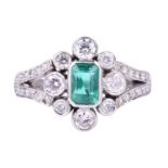 A platinum, diamond, and emerald ringcentred with an emerald-cut emerald of approximately 0.70